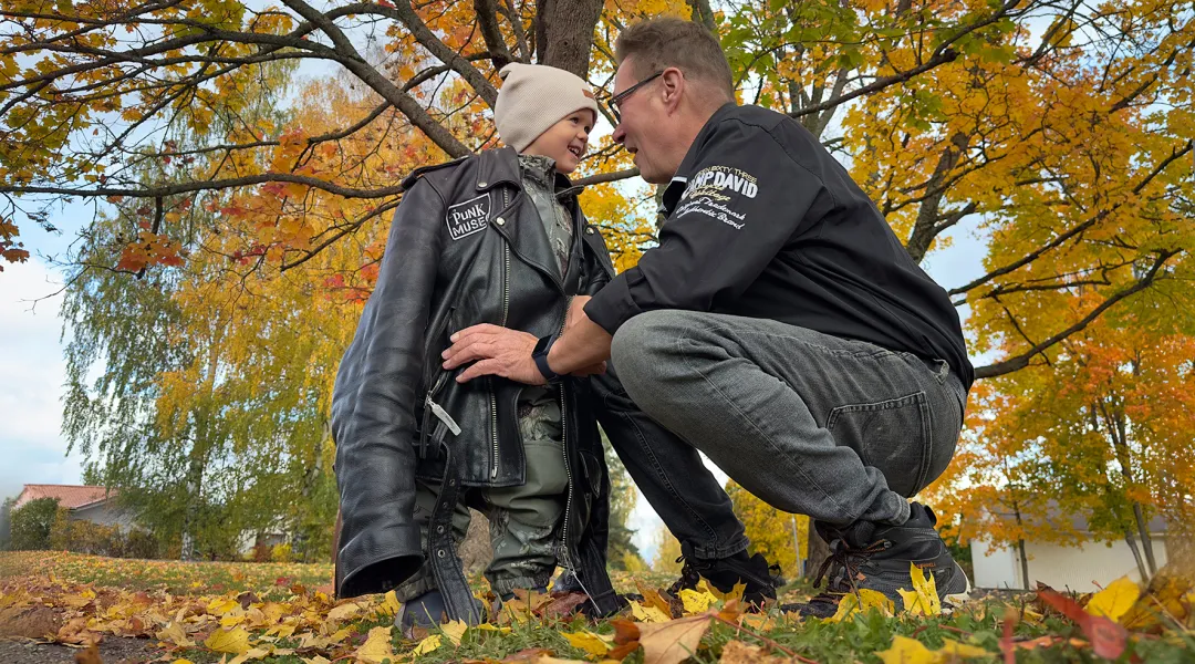 Timo Murkka ja Milo, 3, vaahteranlehtien keskellä. Milolla on päällään isänsä nahkatakki.