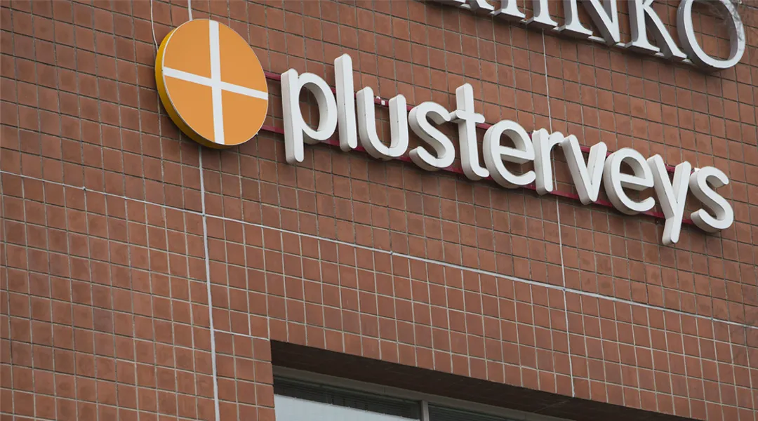 Plusterveyden logo rakennuksen tiiliseinällä.