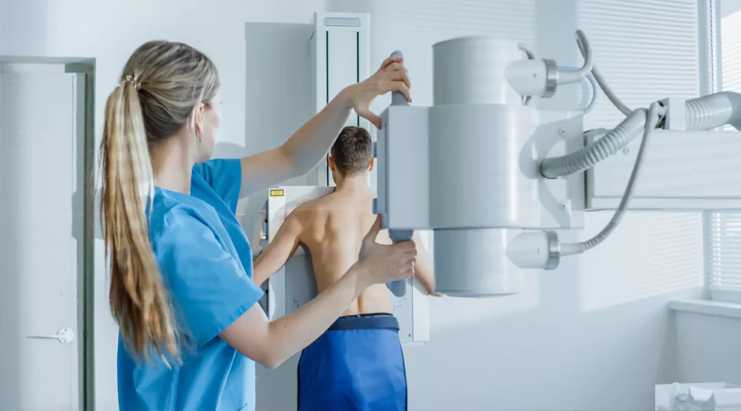 röntgenhoitaja valmistautuu kuvaamaan selkää  