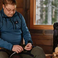 Kari Mänttäri ja pääkalloveistos, jonka päällä istuu korppi.