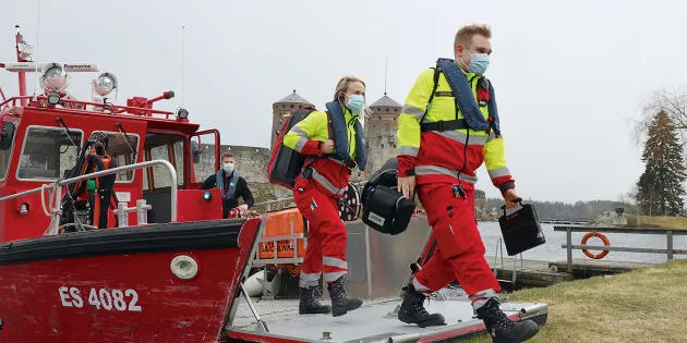 Ensihoitajat astuvat veneestä rannalle.