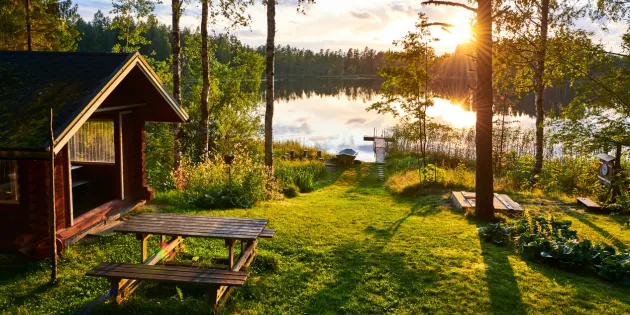 Mökki ja järvenranta auringonlaskussa.