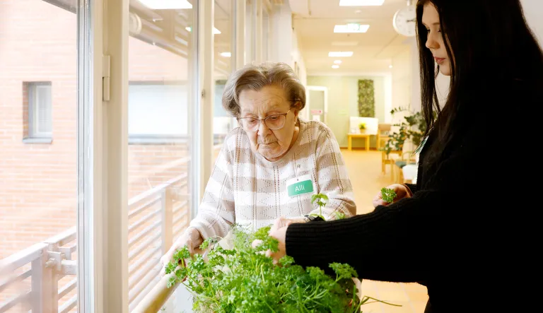 Alli Brotherus huolehtii ryhmäkodin yrteistä. Hän on kastelureissulla yhdessä lähihoitaja Venla Nissisen kanssa.